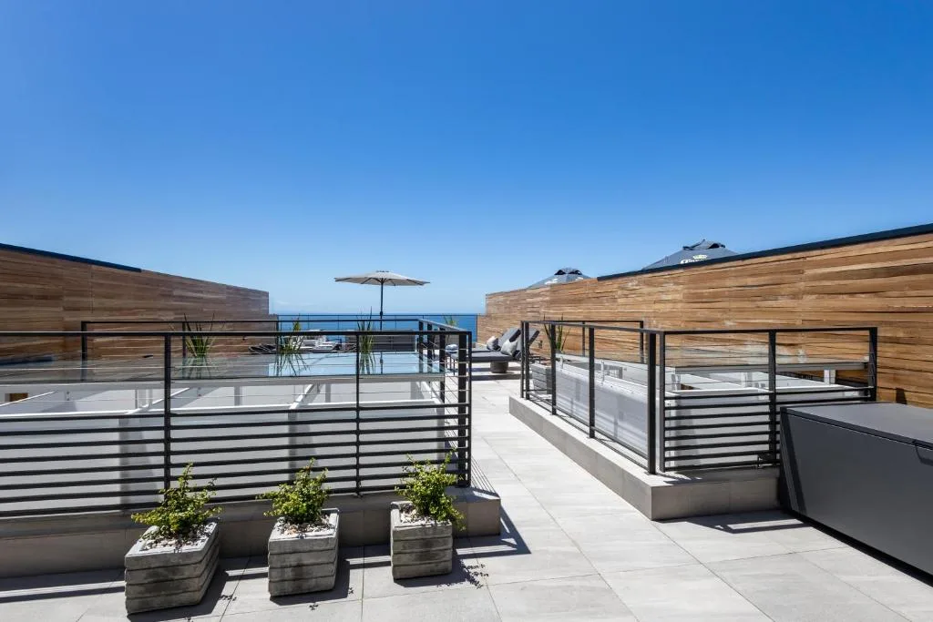 Modern rooftop deck with ocean views, wooden screening, and lounge seating
