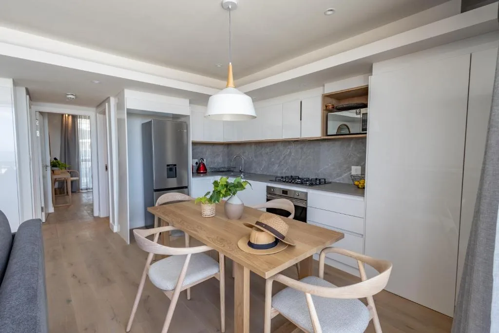 Modern dining table with wooden chairs in open-plan kitchen area