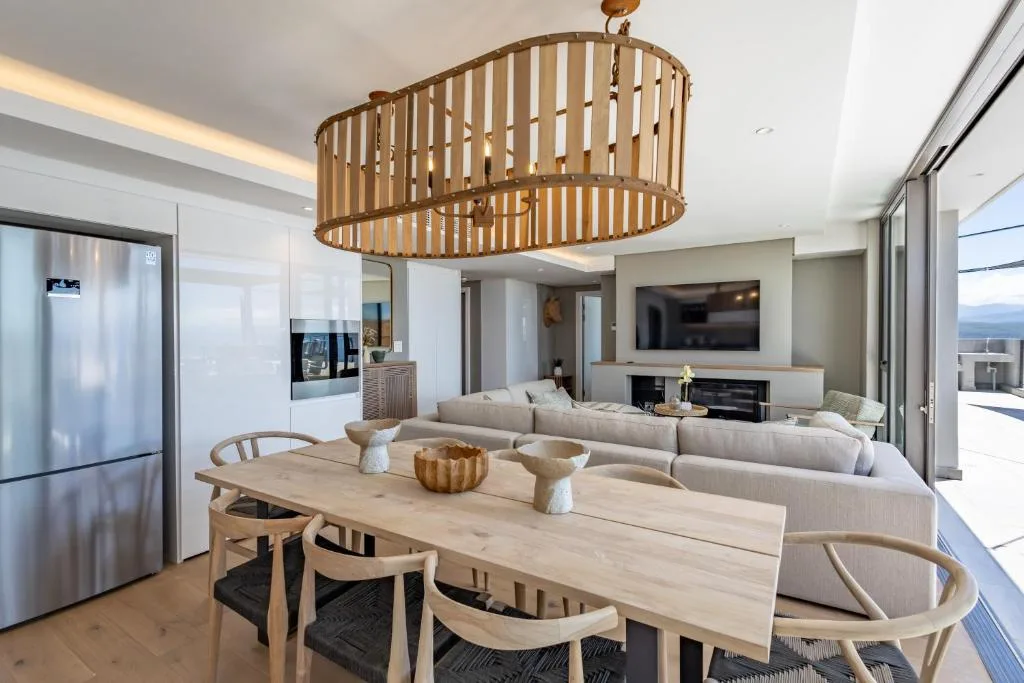 Modern dining area with wooden table, chairs, and pendant light fixture