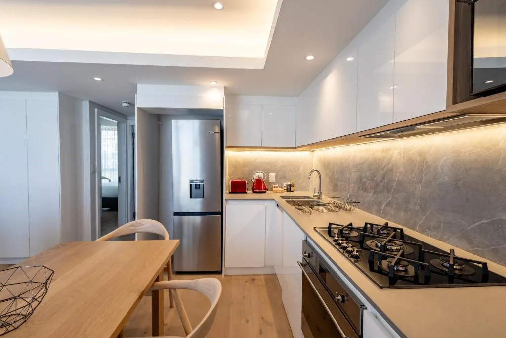 Modern kitchen with gas cooktop, stainless steel appliances, and dining table