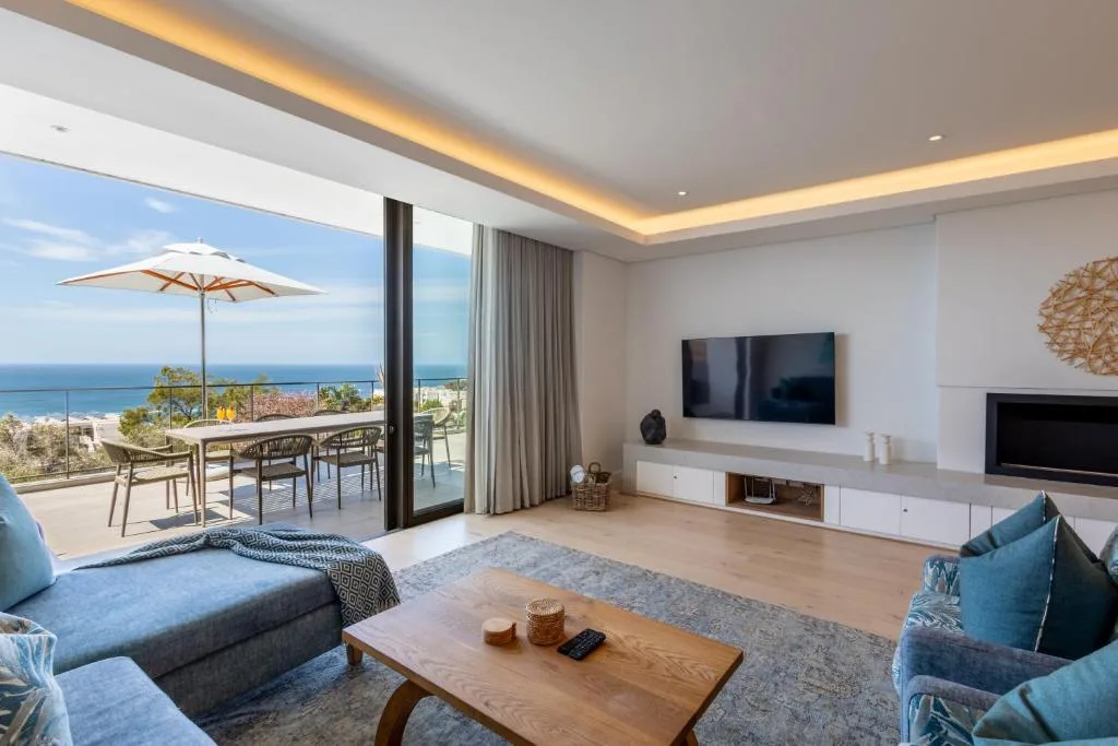 Spacious modern lounge with ocean views, sofa seating, and wall-mounted television