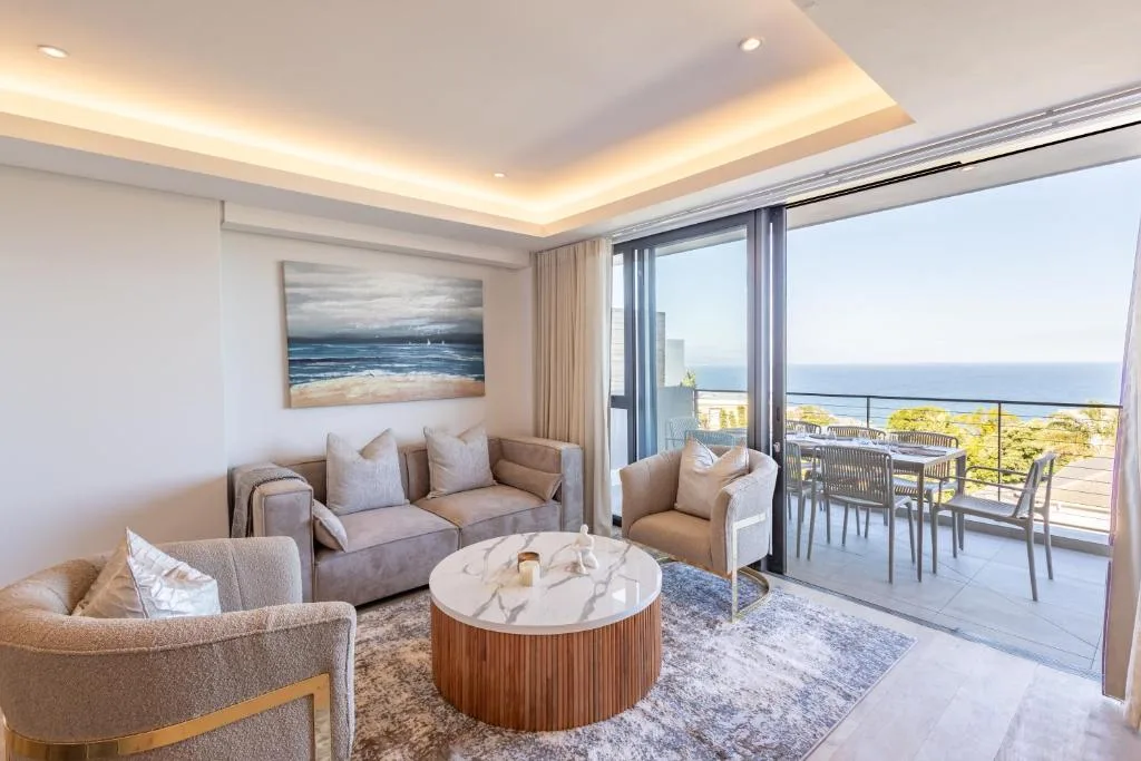 Modern lounge with ocean views through floor-to-ceiling windows and coastal artwork