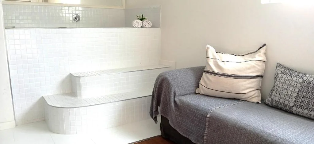 Modern white bathroom with soaking tub and decorative rolled towels