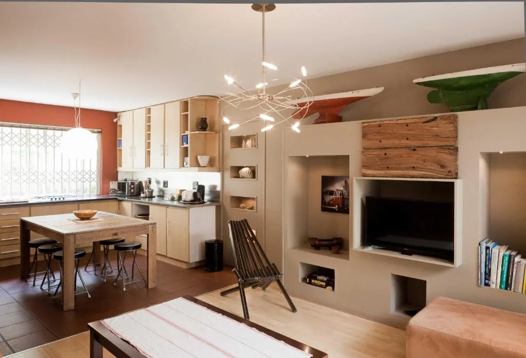 Modern living room with TV, fireplace, and contemporary pendant lighting fixture