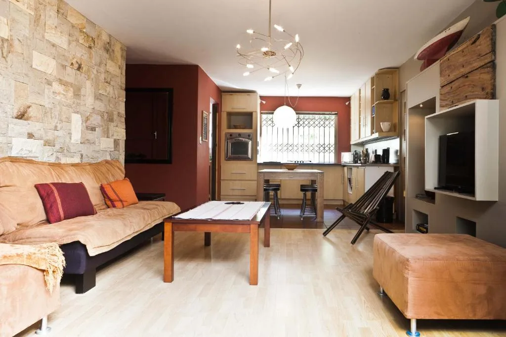 Open-plan lounge with cream sofa, wooden coffee table, and kitchen visible beyond