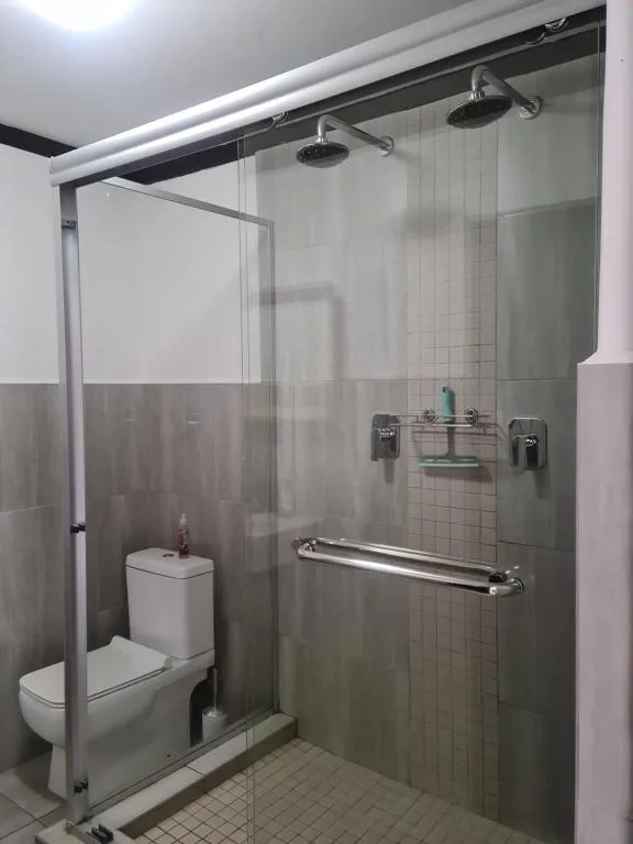 Modern bathroom with walk-in shower, dual showerheads, and white toilet