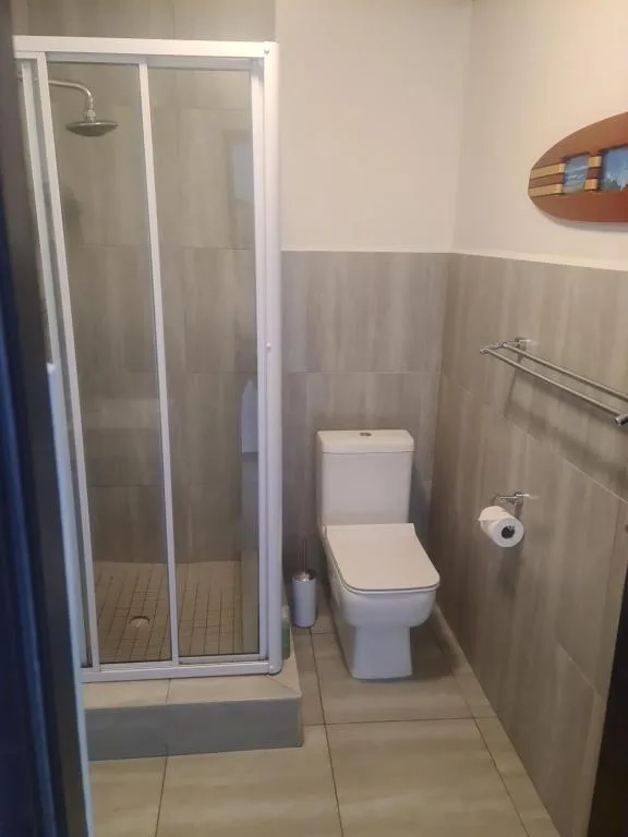 Bathroom with shower cubicle, toilet, and towel rail fixtures