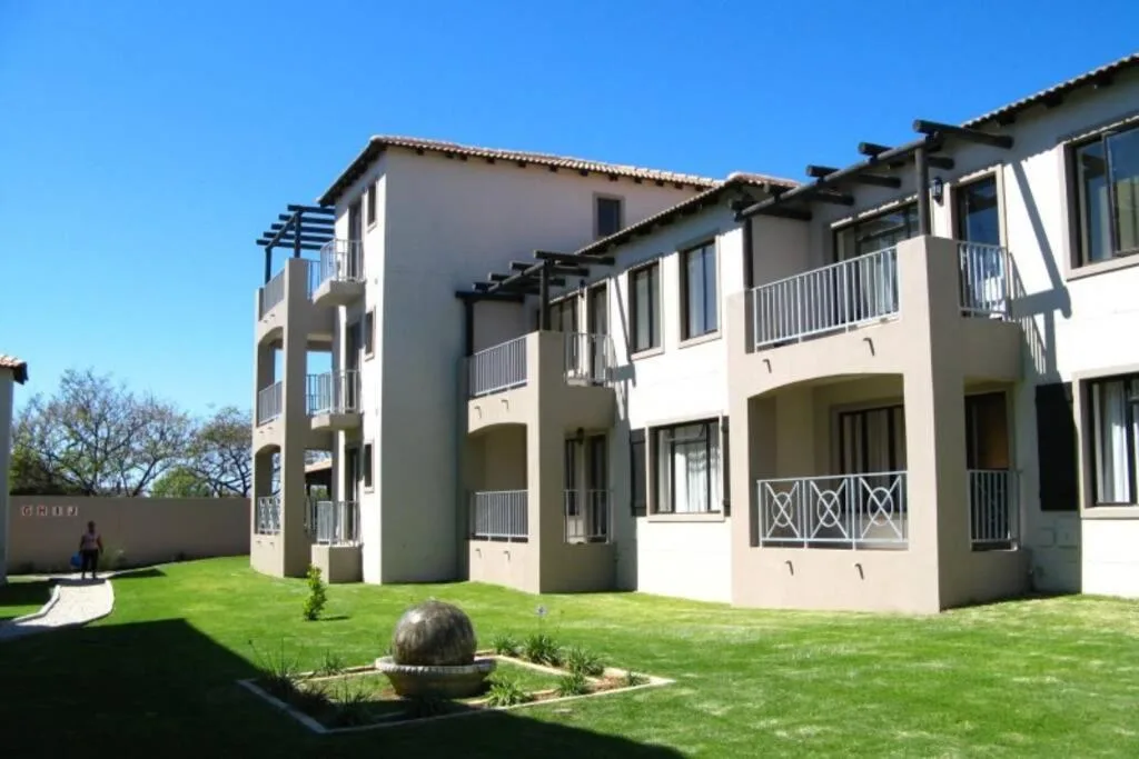 Modern apartment complex with manicured gardens and multiple balconies