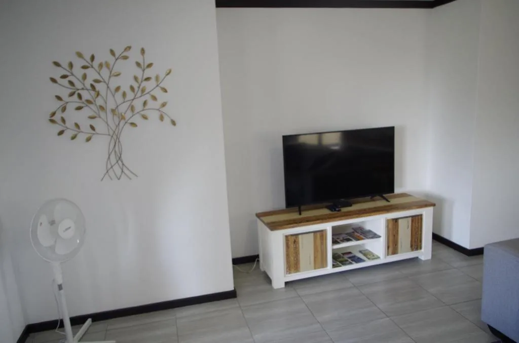 Modern lounge with TV on wooden media unit and wall art