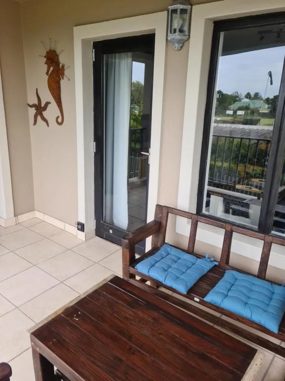 Bright lounge interior with wooden furniture and glass doors overlooking garden