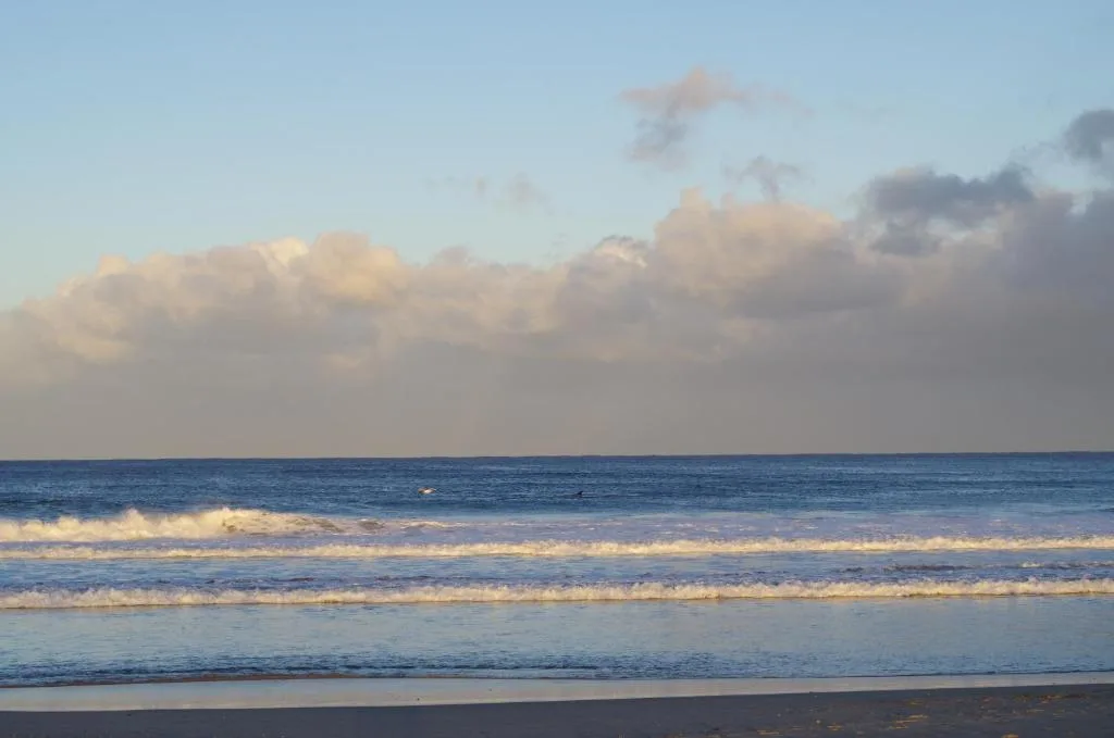 Serene ocean view with waves and dramatic cloudy sky at sunrise