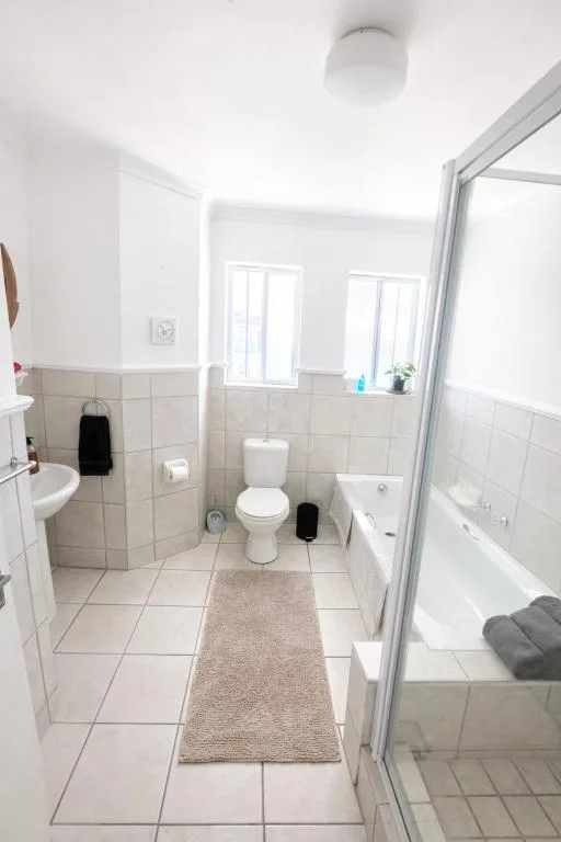 Clean bathroom with toilet, sink, bathtub and shower enclosure