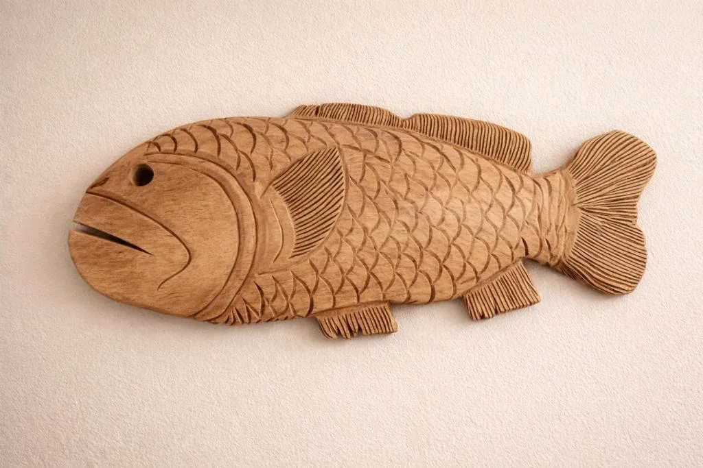 Hand-carved wooden fish sculpture with intricate scale and fin detailing