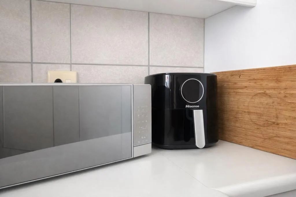 Modern kitchen counter with microwave and black air fryer appliance