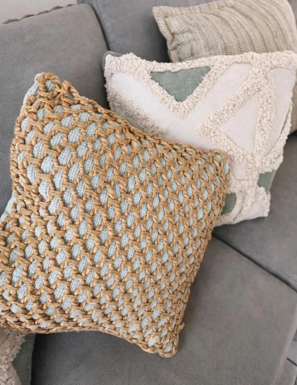 Gray sofa with decorative woven and textured cushions in neutral tones