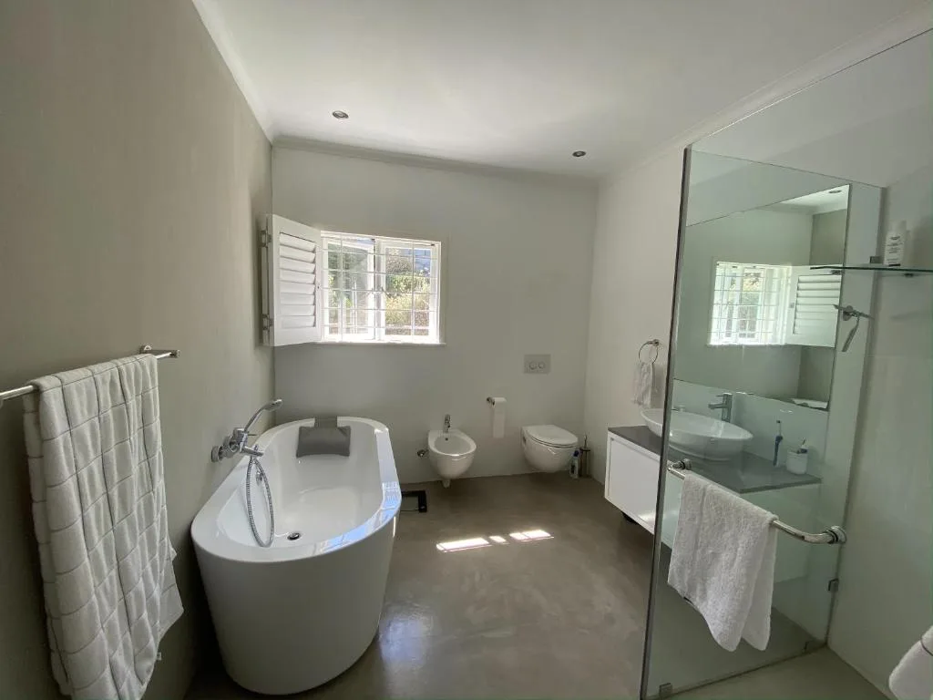 Modern bathroom with freestanding tub, rainfall shower, and double vanity
