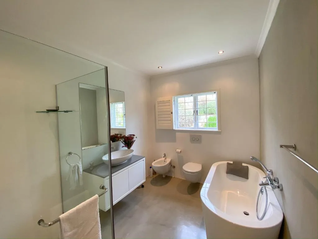 Modern bathroom with freestanding tub, walk-in shower, and dual vanity sink