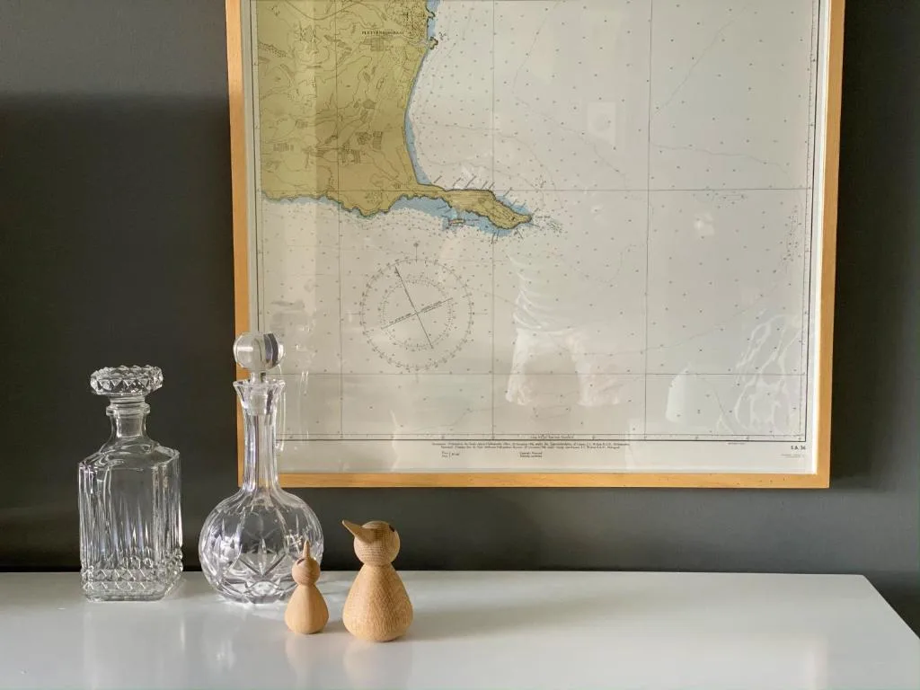 Nautical map and crystal decanters with wooden figurines decor display