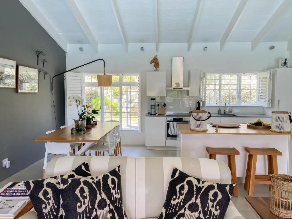 Modern open-plan kitchen with white cabinetry, wooden island, and dining area