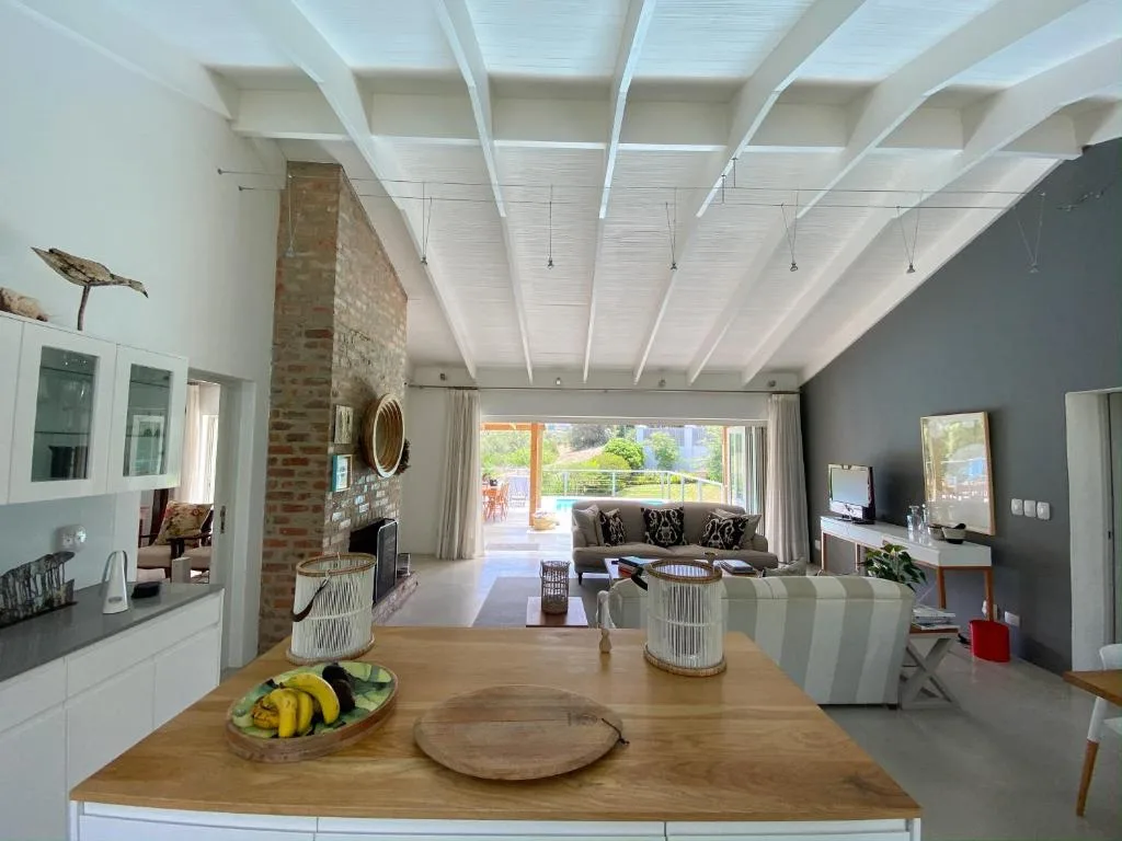 Open-plan living space with sofa, fireplace, and garden views through large doors