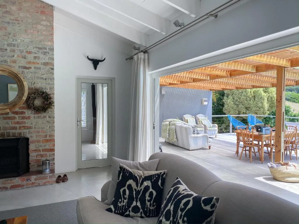 Modern lounge with fireplace opens to covered deck and ocean views