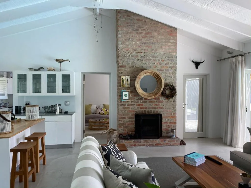 Open-plan lounge with fireplace, sofa, and exposed brick feature wall