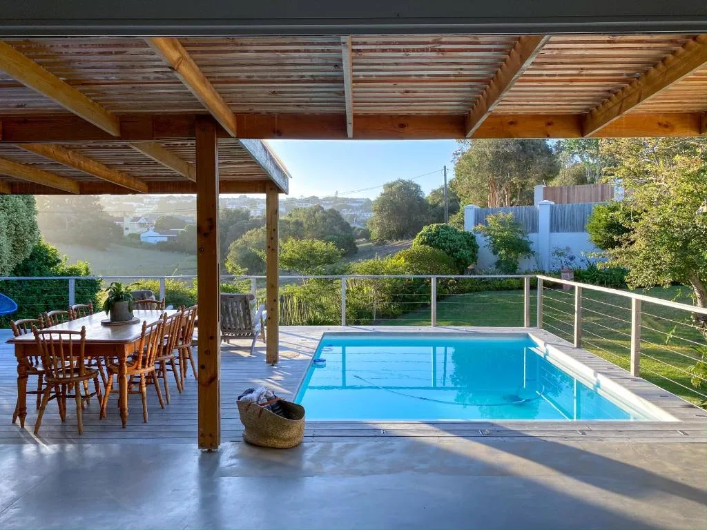 Sparkling blue swimming pool on wooden deck with river views