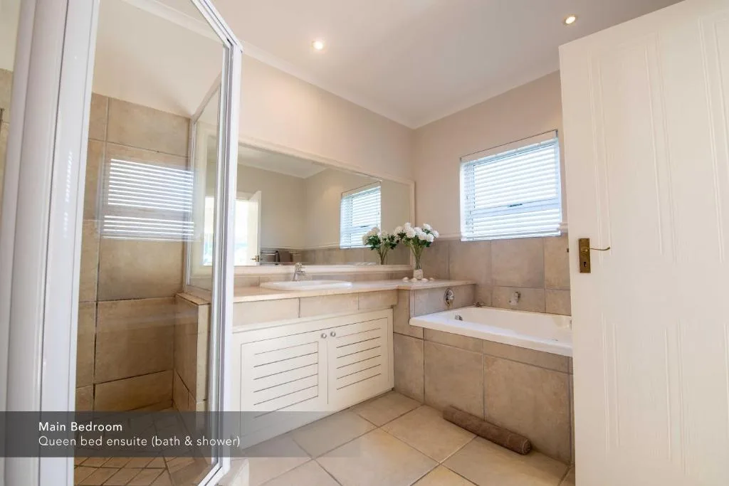 Spacious ensuite bathroom with shower enclosure, bathtub, and dual vanity