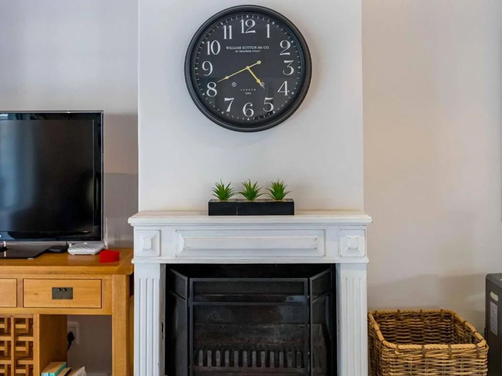 Elegant fireplace mantel with clock, succulents, and decorative items