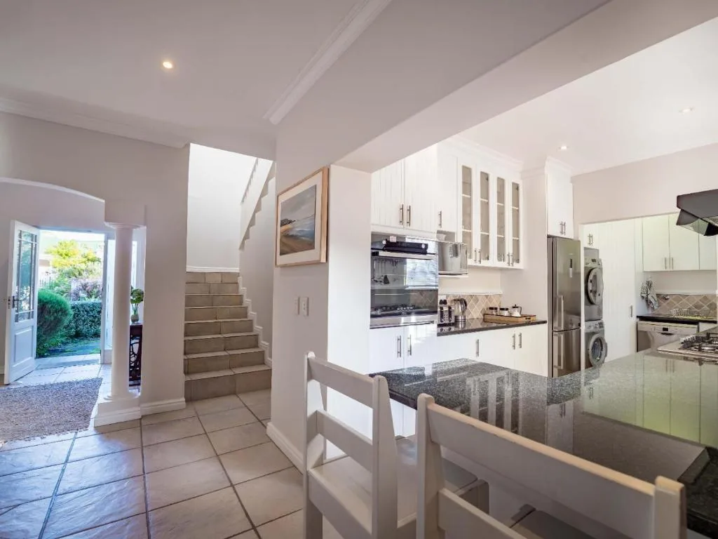 Modern kitchen with white cabinetry, stainless steel appliances, and granite countertop