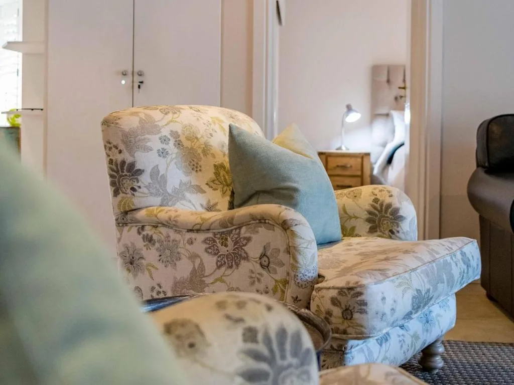 Floral upholstered armchair with blue cushion in bright lounge space