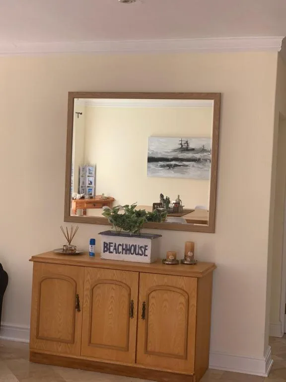 Wooden cabinet with mirror, beachhouse decor, and coastal artwork display