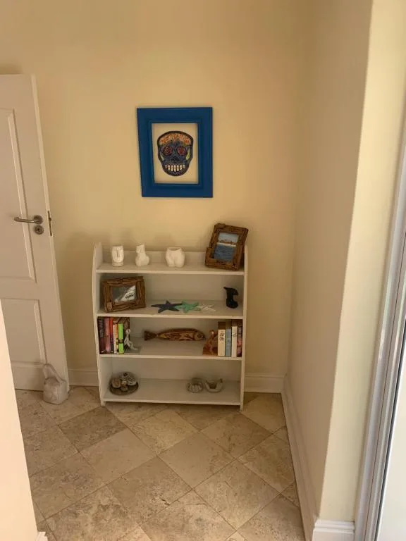 White shelving unit displaying decorative items and artwork in hallway