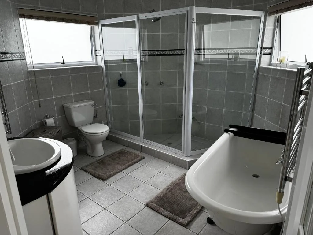 Modern bathroom with shower enclosure, freestanding tub, and dual vanities