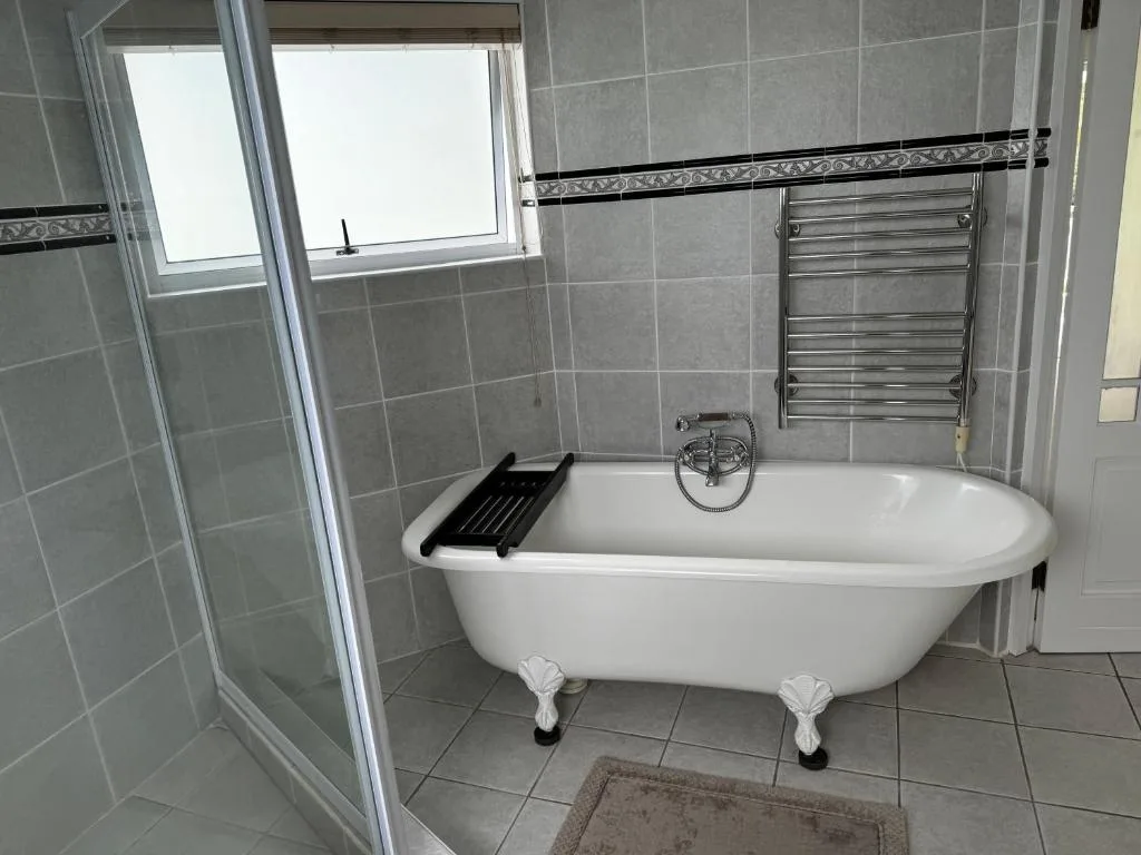 Modern bathroom with freestanding bathtub, rainfall shower, heated towel rack