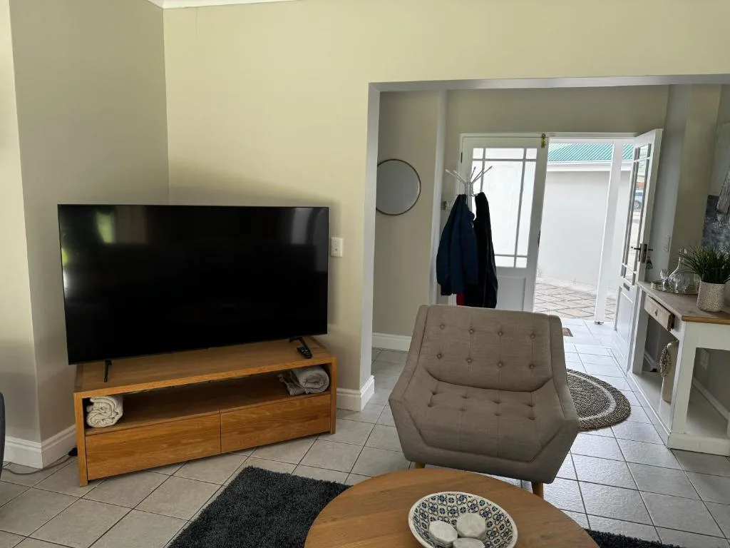 Spacious living room with flat-screen TV, wooden furniture, and modern décor
