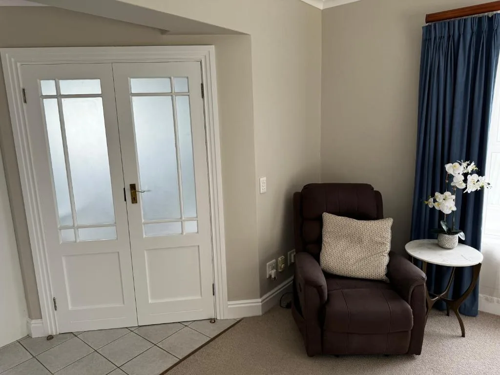 Cozy lounge corner with dark leather recliner and white flowers