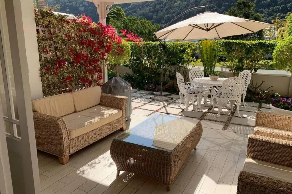 Spacious patio with wicker furniture, umbrella, and mountain views