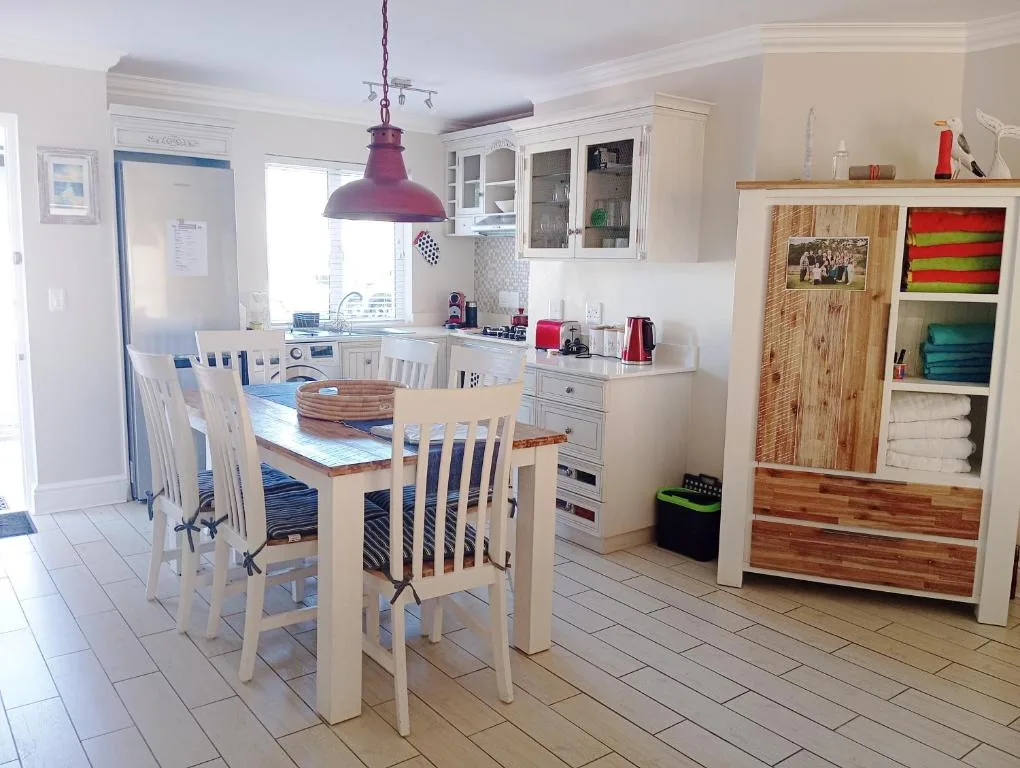 Modern kitchen and dining area with white cabinetry and pendant lighting