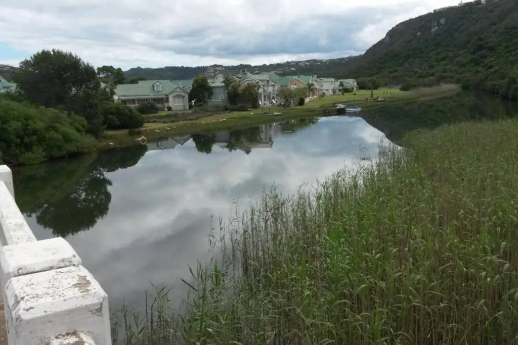 Scenic lagoon view with lush green mountains and waterfront properties