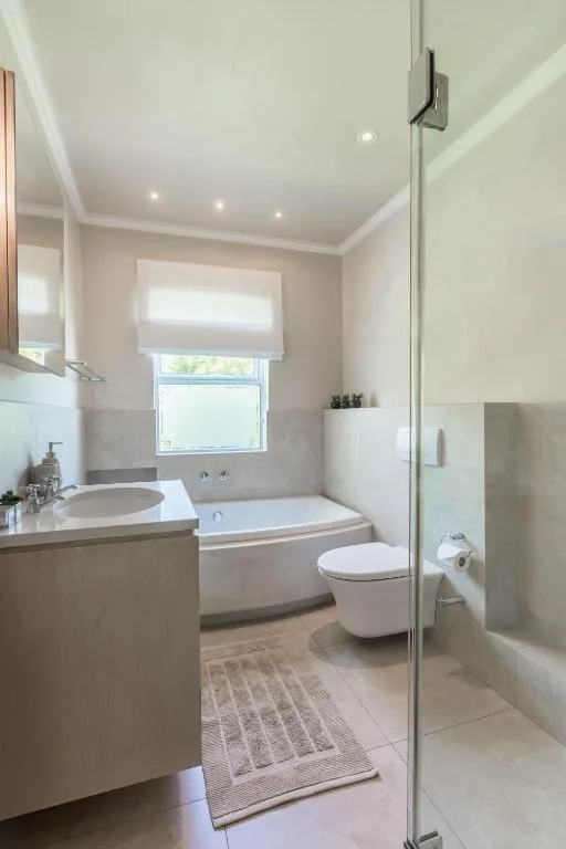 Modern bathroom with vanity, toilet, bathtub, and glass shower enclosure