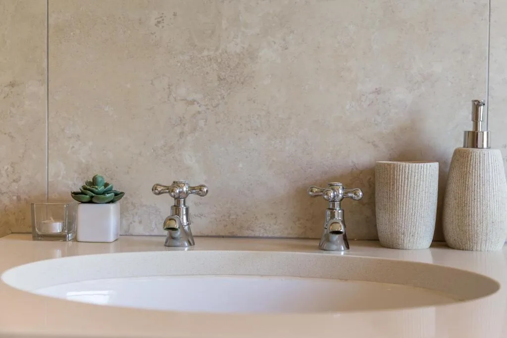 Elegant bathroom vanity with oval basin, chrome taps, and decorative accessories