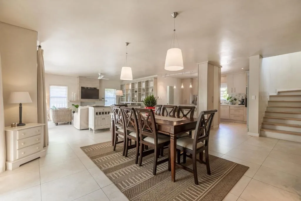 Dining table with dark wood chairs and pendant lighting in open-plan home