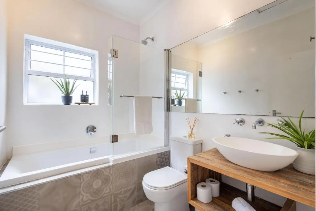 Modern bathroom with bathtub, walk-in shower, and vessel sink on wooden vanity