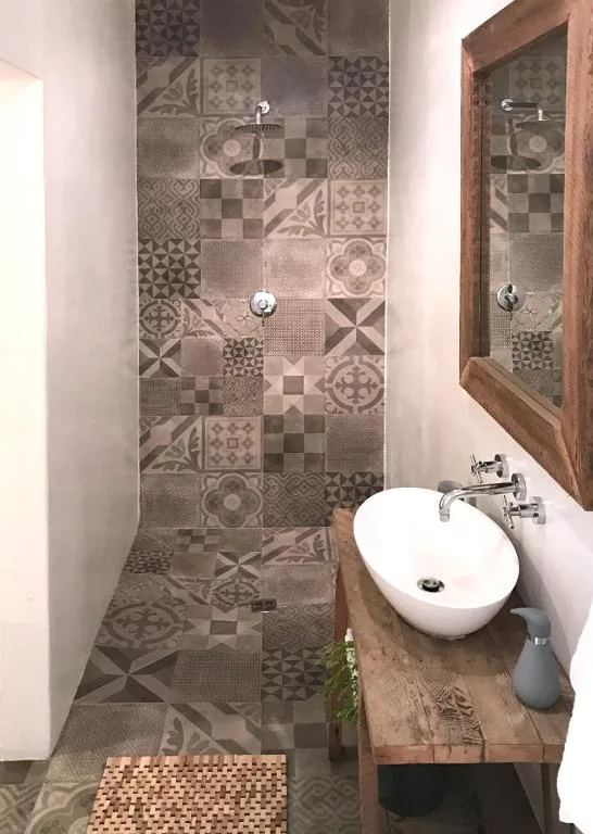 Modern bathroom with patterned tile shower and round white basin sink