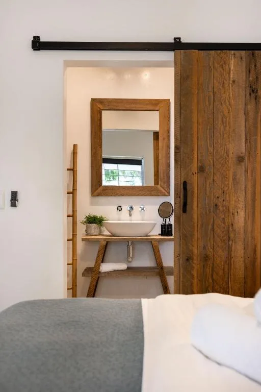 Rustic wooden-framed mirror above vessel sink in modern bathroom