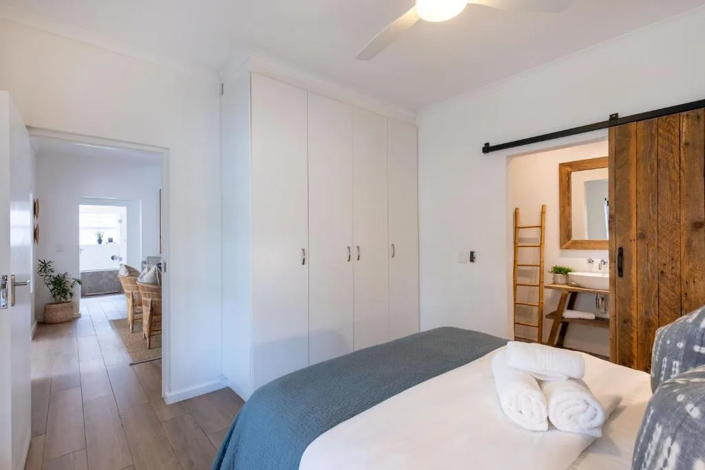 Modern bedroom with white built-in wardrobes and ensuite bathroom access