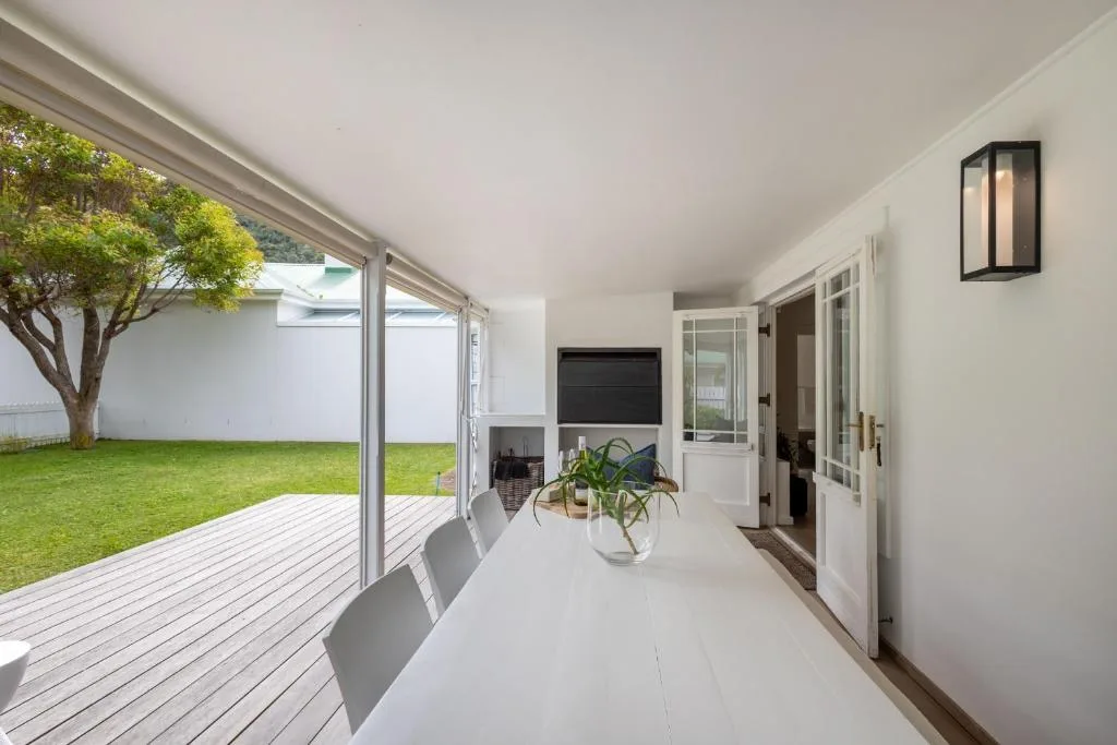 Modern deck with dining table overlooking manicured lawn garden