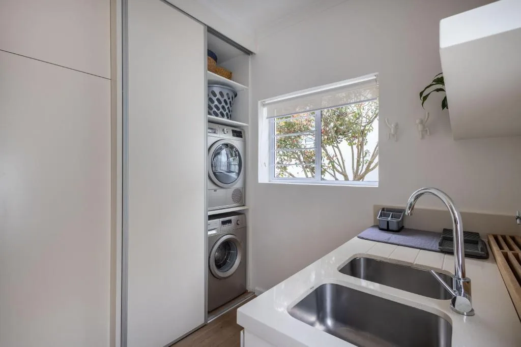 Modern laundry room with stacked washer and dryer appliances
