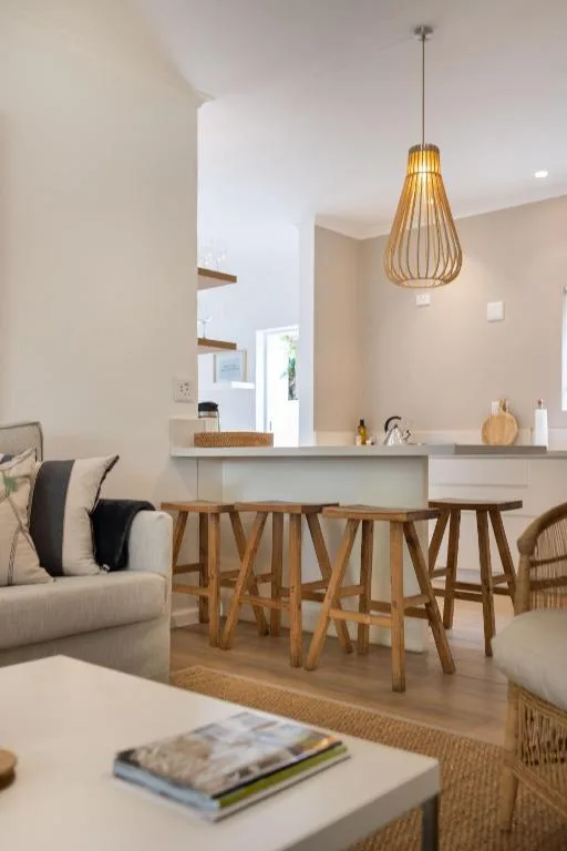 Open-plan lounge with bar seating, pendant lighting, and neutral decor